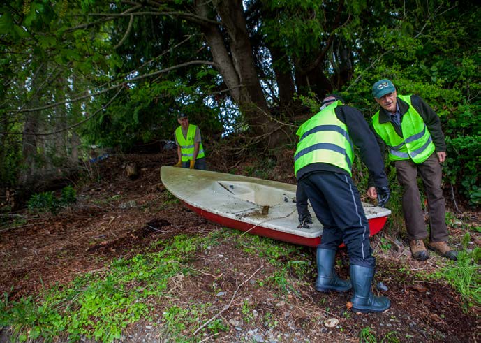 Volunteers remove boats, many derelict, from the hillside and eroded bank.
